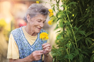 senior woman smelling flowers