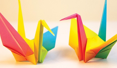 close up of two origami swans made with different colored paper