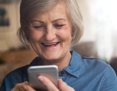 senior woman looking at her cell phone smiling