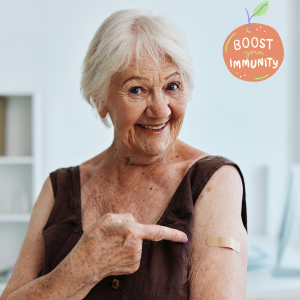 older woman showing off her vaccination shot at doctor’s office